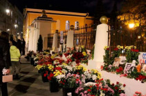 Люди несут цветы к посольству Армении в Москве